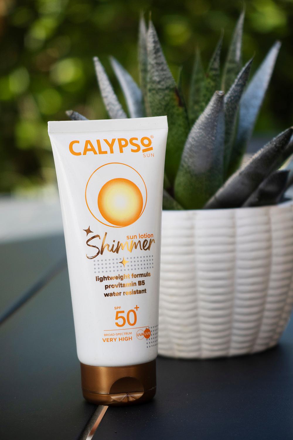 Calypso Shimmer Sun Lotion SPF50 Lifestyle on a table