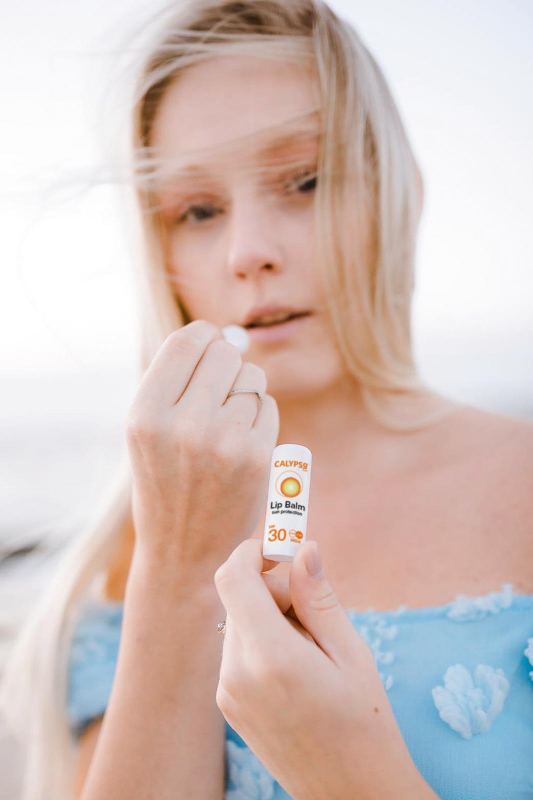 Calypso lip balm used on a beach in a cloudy day