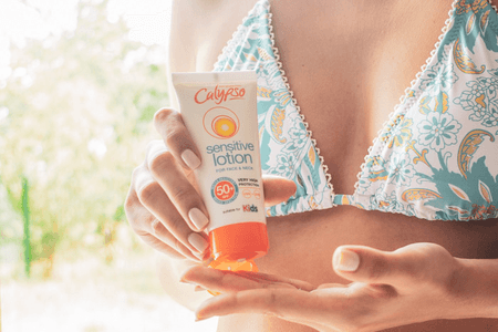 Woman in a bikini applying some Calypso Sensitive Lotion for Face and Neck